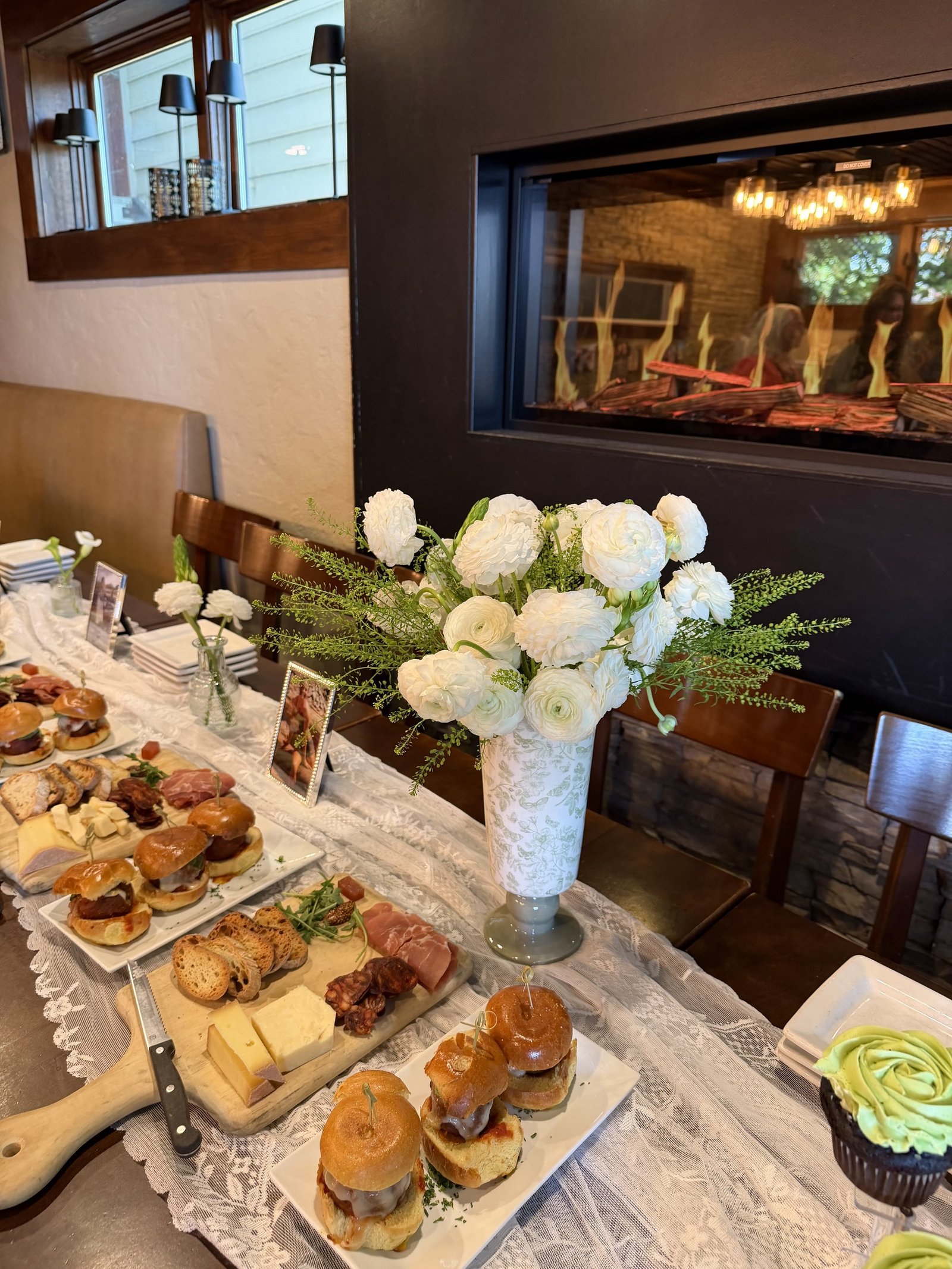 Charcuterie spread by the fireplace with white florals