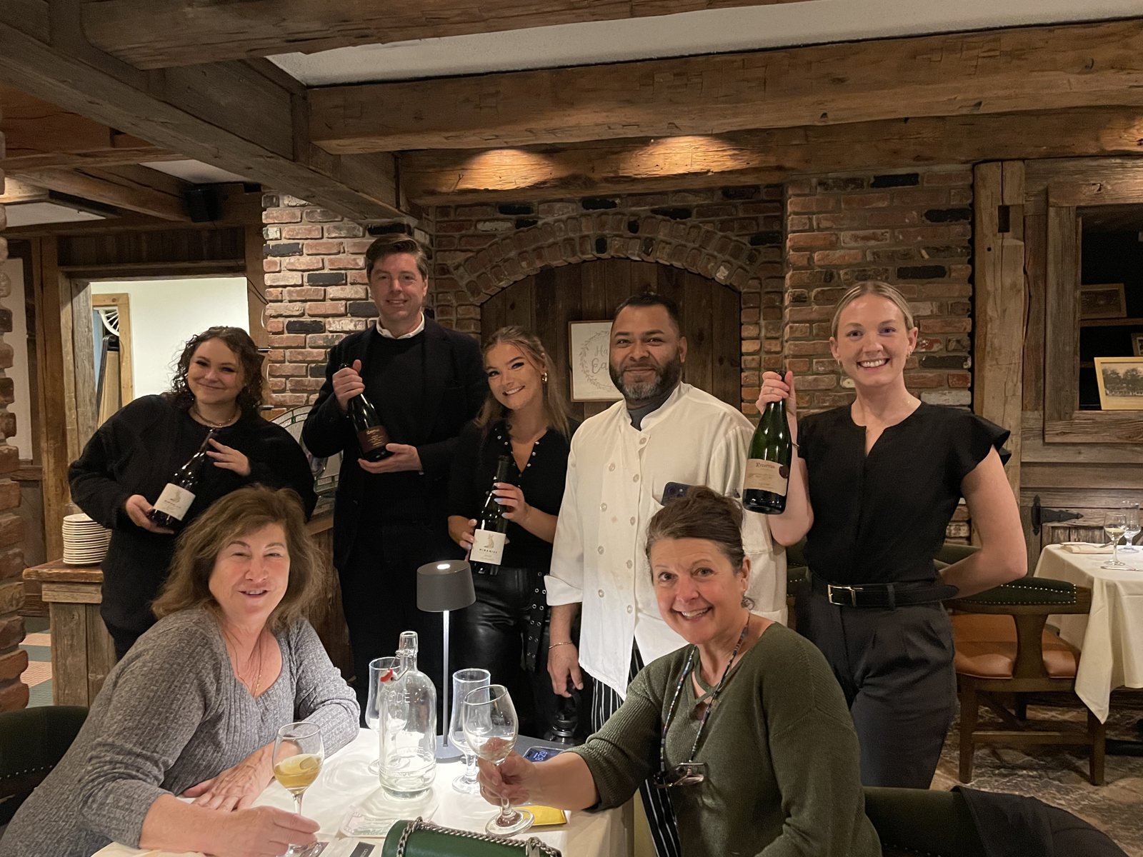The team at a tasting event, holding the wines they poured that night.